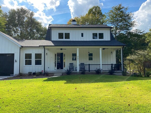 A two-story house with a covered porch and a garage.