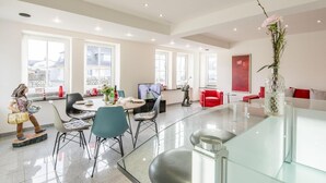 A spacious living room with a dining area, large windows, and a modern design.