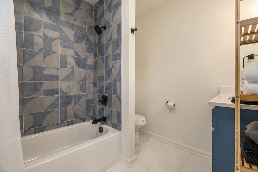 Une salle de bain comprenant une baignoire, des toilettes et un espace douche.