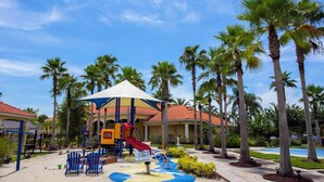 A children's play area with a slide, swings, and a covered seating area. - 3BR Townhome Near Disney I Resort Pool, Hot Tub & Disney-Themed Room (Kissimmee)
