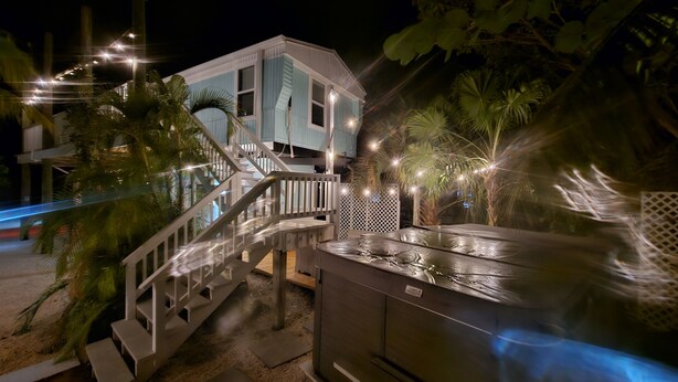 A two-story building with a light blue exterior, a wooden staircase, and a pool area. - 200ft of Waterfront with Tiki & Heated Pool - Boaters Paradise  (Key Largo)