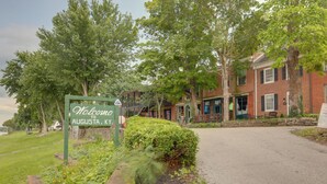 Um edifício de tijolos com uma placa verde que acolhe visitantes em Augusta, KY.