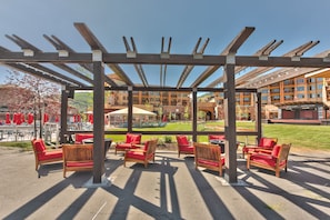 An outdoor patio with wooden furniture and a pergola structure. - Beautiful Pool Golf Hiking Biking Balcony Village Center Perfect Summer Getaway (Park City)