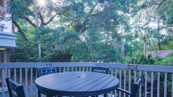 Enjoy an outdoor space with a round table and four chairs overlooking a serene landscape and body of water.