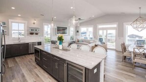 A spacious kitchen with dark cabinets, a marble island, and pendant lighting. - Beautiful Large 5 BR, 4.5 Beach Oasis Close, amazing ocean views and a private pool!  The Seaquel (Oak Island)