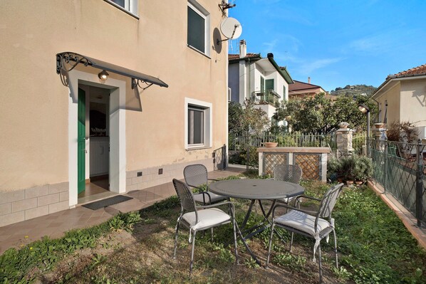 A house with a patio, outdoor seating, and a satellite dish.