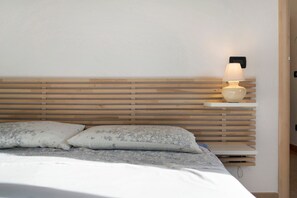 A bed with wooden slats, a bedside lamp, and two pillows. - Vacation Home "Santa Lucia" with Garden (Imperia)
