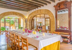 A dining area with a long table set for a meal, wooden chairs, and a large mirror. - Country House 'Historica House with Pool Free Wifi' with Mountain View, Wi-Fi and Air Conditioning (Andratx)