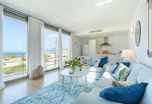 Ein modernes Wohnzimmer mit einer Couch, einem Couchtisch und Meerblick.