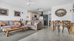 Un salon comprenant un canapé, une table basse et un coin repas avec des chaises et une table.