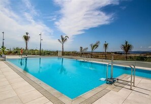 A swimming pool with a tiled deck, metal railings, and palm trees in the background. - Apartment "Panorama III" Near the Beach with Pool (Torrox Costa)