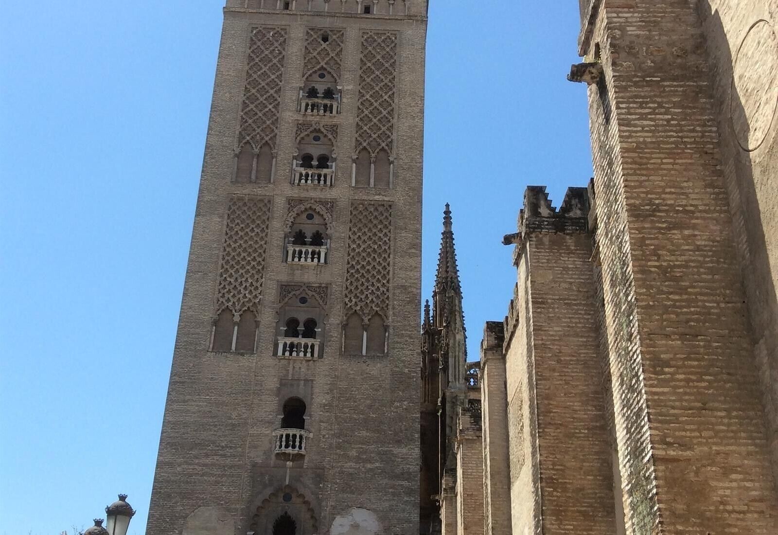 Una torre alta y antigua con detalles arquitectónicos elaborados y un cielo despejado.