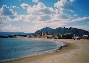 A beach with a mountain in the background, a clear sky, and a few buildings near the water. - Apartment in Bolnuevo with Sea View, Shared Pool, A/C & Wi-Fi (Bolnuevo)