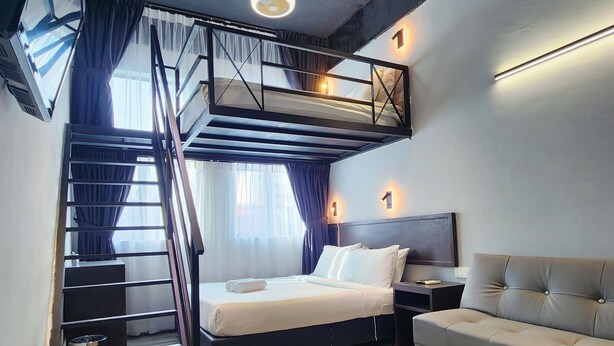 Une chambre moderne avec un lit superposé, un canapé, une télévision et un escalier.