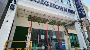 La façade de l’hôtel Georgetown Inn, avec une enseigne indiquant la présence d’une épicerie et une entrée bien visible.