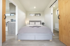 Une chambre à coucher avec un lit, une table de chevet et une fenêtre.