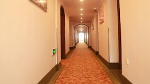 A hotel hallway with a carpeted floor, a light-colored wall, and a ceiling with recessed lighting. - Greentree Inn Shanghai Minhang District Pujiang Town Jiangyue Road Metro Station (Shanghai)