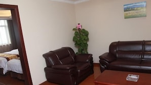 A hotel room with a bed, a brown leather sofa, a wooden coffee table, and a potted plant. - Greentree Inn Shanghai Minhang District Pujiang Town Jiangyue Road Metro Station (Shanghai)