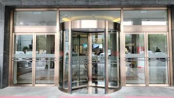 A revolving door entrance with glass panels and a metallic frame.