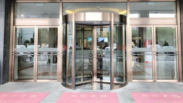 A revolving door entrance with glass panels and a metallic frame. - Greentree Inn Shanghai Minhang District Pujiang Town Jiangyue Road Metro Station (Shanghai)