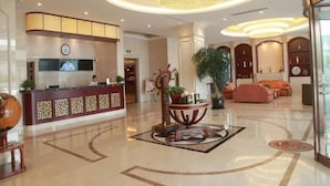 A hotel lobby with a reception desk, a large chandelier, a seating area with sofas, and a decorative table with plants. - Greentree Inn Shanghai Minhang District Pujiang Town Jiangyue Road Metro Station (Shanghai)