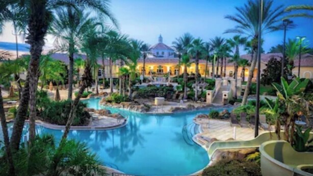A resort with a central swimming pool, palm trees, and a building with a dome roof. - 4 BR Home in Prestigious Regal Palms Resort, waterpark, close to theme parks. (Davenport)