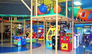 An indoor play area with various arcade games and a climbing structure.