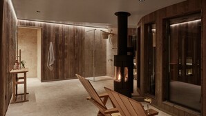 A modern bathroom with a wood-paneled wall, a glass shower enclosure, and a wood-burning stove. - RUNO Hotel Porvoo (Porvoo)
