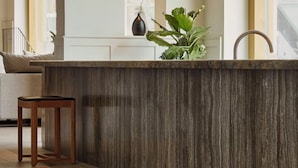 A modern kitchen with a dark wood countertop, a wooden stool, and a plant. - RUNO Hotel Porvoo (Porvoo)