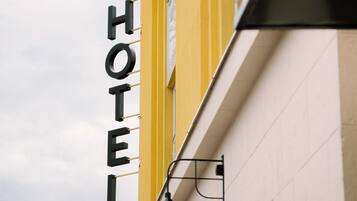 Segnaletica di un hotel con la scritta 'HOTEL' a caratteri grandi su un edificio giallo.