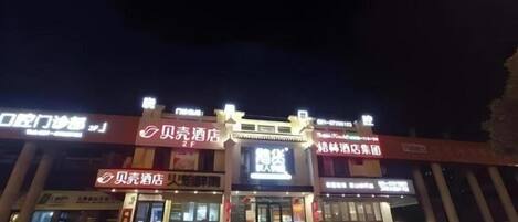 A building with multiple signs, including one for a hotel and another for a store.