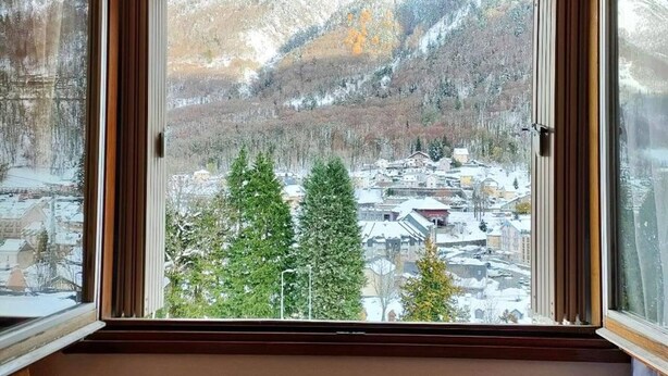 A window with a view of a snowy landscape, including trees and buildings. - 2-Bedroom Apartment with Parking, Sleeps 4/6 (Cauterets)
