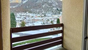 A balcony with a view of a snow-covered town and mountains. - 2-Bedroom Apartment with Parking, Sleeps 4/6 (Cauterets)