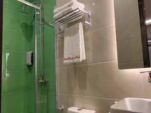 A bathroom with a glass-enclosed shower, a white sink, and a towel rack with a towel hanging on it. - Shell Beijing Fangshan Chengguan Metro Station Hotel (Fangshan)
