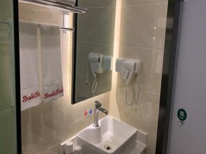 A bathroom with a sink, a towel rack, and two hair dryers mounted on the wall. - Shell Beijing Fangshan Chengguan Metro Station Hotel (Fangshan)