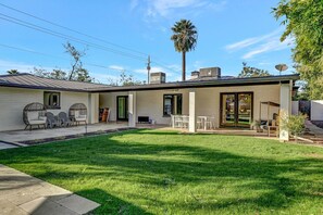 A modern house with a covered patio, a lawn, and a palm tree. - Upscale Remodel - Walk to ASU; Pool & Pickleball (Tempe)