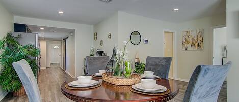 A dining area with a round table, four chairs, and a decorative centerpiece.