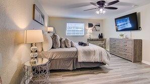 A bedroom with a bed, bedside tables, a ceiling fan, a TV, and a window. - Perfect family Get-Away! (Tampa)