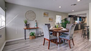 A modern dining area with a round table, two chairs, and a decorative centerpiece. - Perfect family Get-Away! (Tampa)