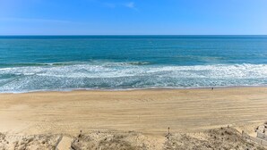 Uma praia com céu claro e ondas do oceano.