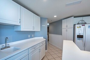 Enjoy cooking in this well-equipped kitchen with a sink, refrigerator, and ample countertop space.
