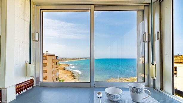 Un balcon avec vue sur la plage et l’océan.