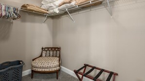 A laundry area with a chair, a bench, and a shelf with towels and folded clothes. - 3's a Birdie - 2BR, 2BA Condo, Golf & Mountain View (Maggie Valley)