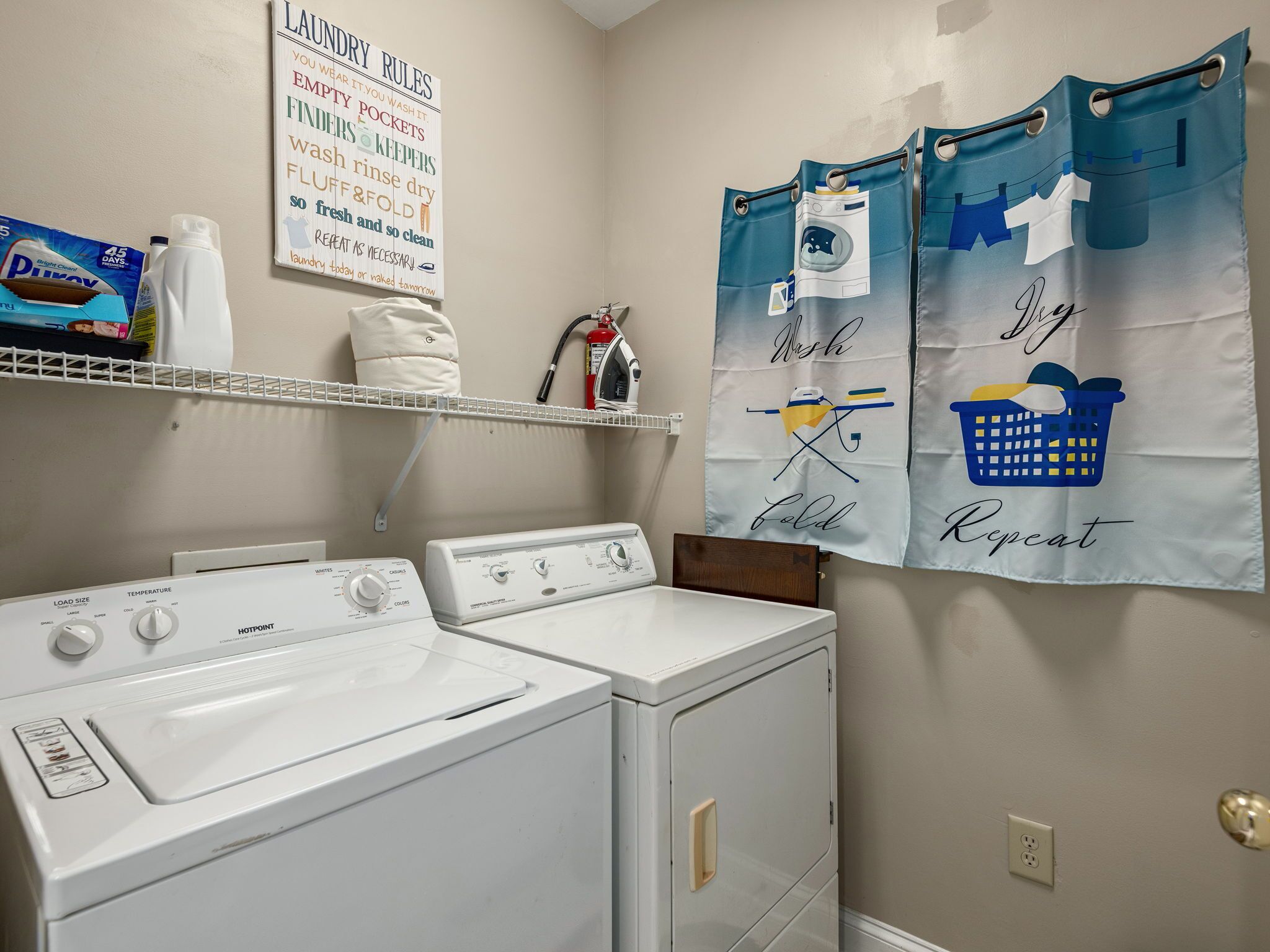 A laundry area with a washing machine, dryer, and a wall-mounted drying rack.