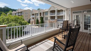 A balcony with outdoor furniture, a view of neighboring buildings, and a clear sky. - 3's a Birdie - 2BR, 2BA Condo, Golf & Mountain View (Maggie Valley)