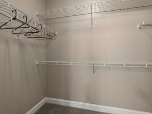 Een kleedkamer met metalen schapunits en een vloerbedekking.