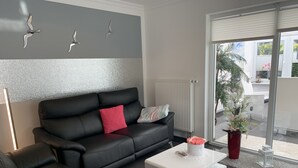 Ein modernes Wohnzimmer mit einem schwarzen Ledersofa, einem weißen Couchtisch und Wanddekoration.