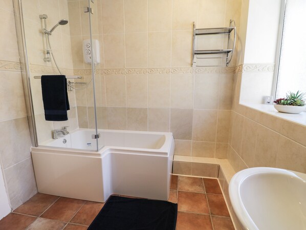 A bathroom with a shower, a bathtub, and a sink.