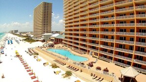 Ein Hotel mit mehreren Balkonen, einem Pool und einer Strandlage.