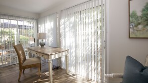 Une pièce comprenant une table à manger, une chaise, une lampe et un tableau accroché au mur.